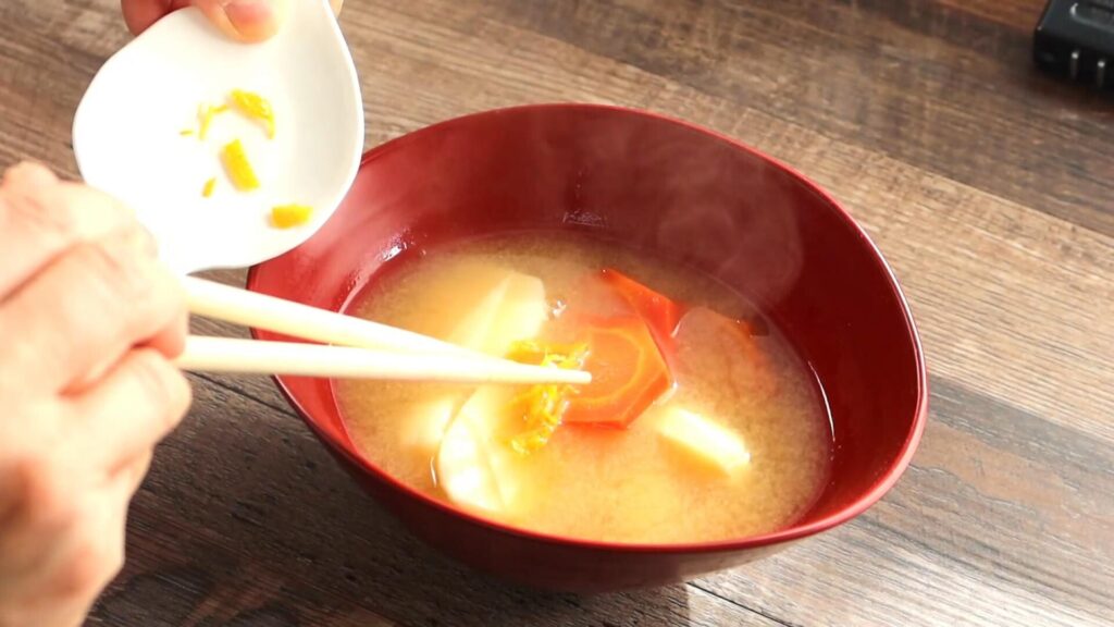 味噌スープに柚子の千切りを添えている画像