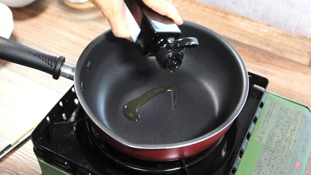 鍋にオリーブオイルを入れている画像