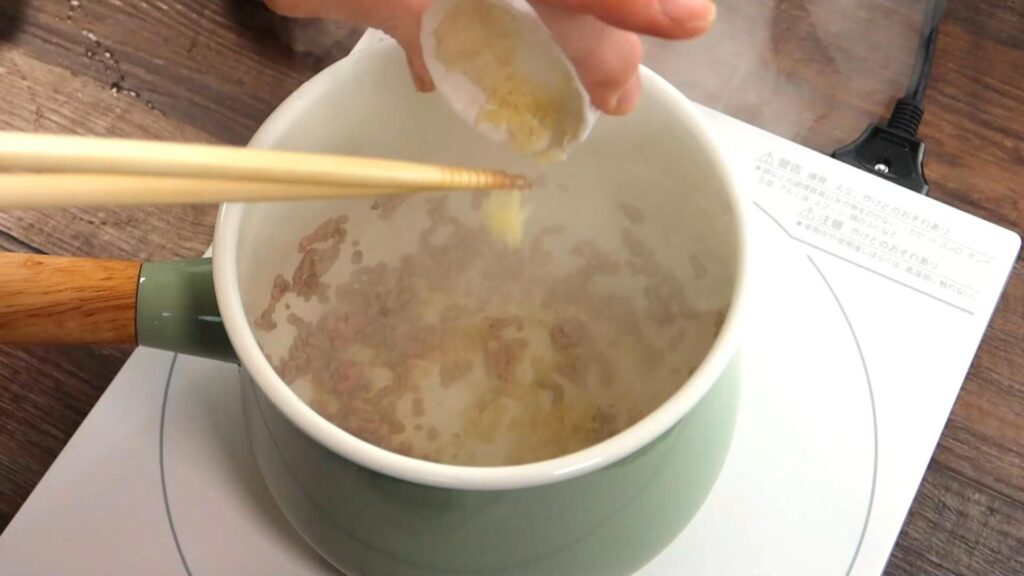 鍋に生姜を入れている画像