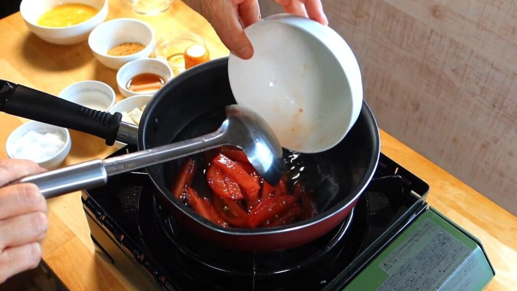 鍋に切ったトマトを入れている画像