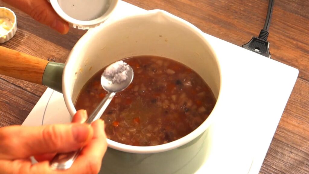 スープに塩を入れている画像