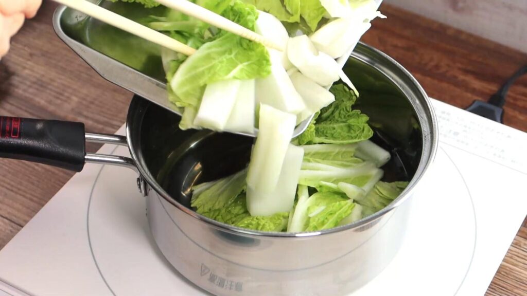 鍋に白菜を入れている画像