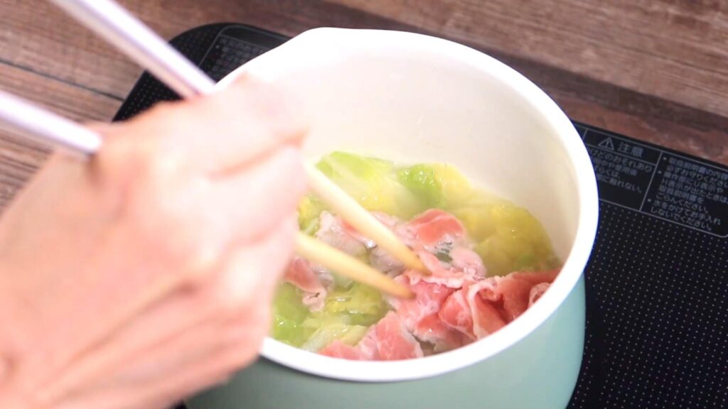 豚バラ肉を鍋に入れている画像