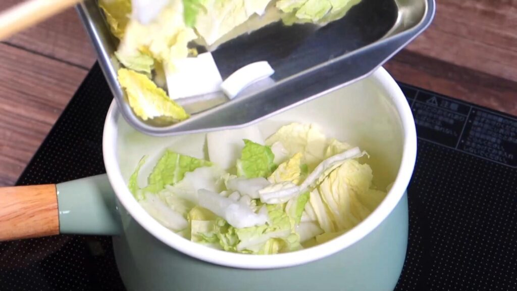 鍋に白菜を入れている画像