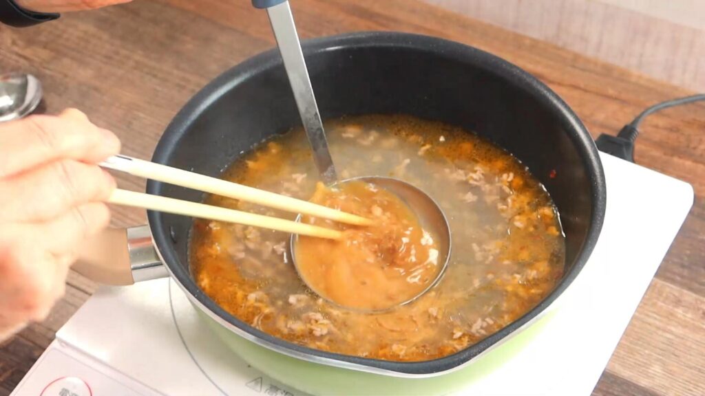 スープに味噌を溶き入れている画像