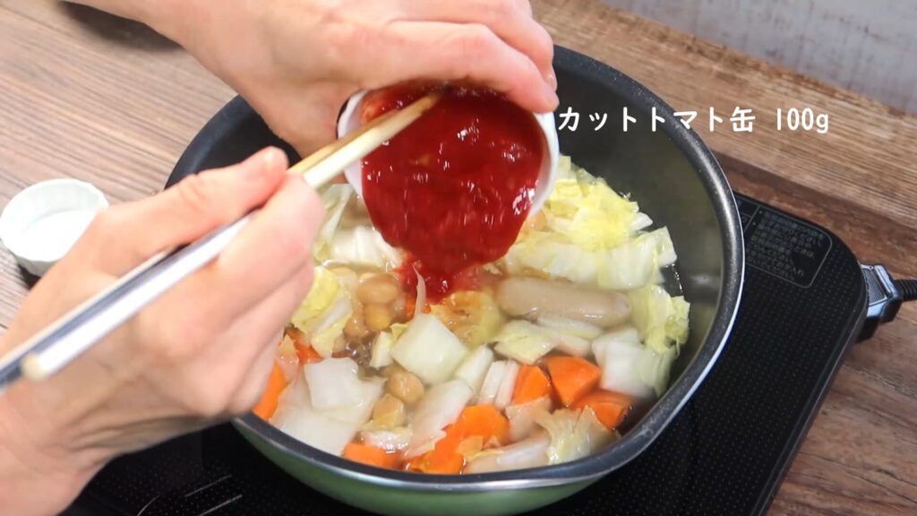 鍋にカットトマトを入れている画像