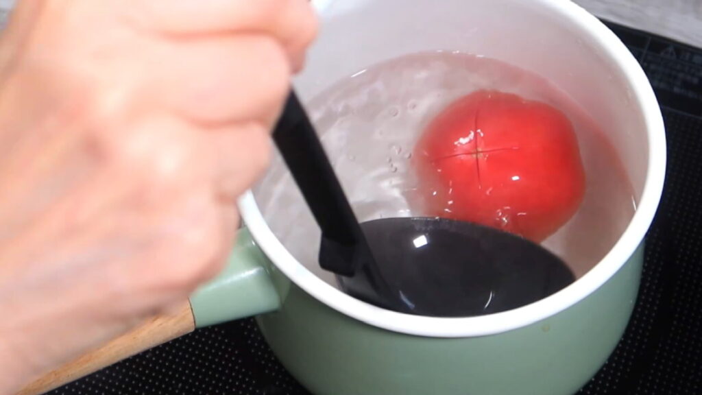 トマトを熱湯につけている画像。