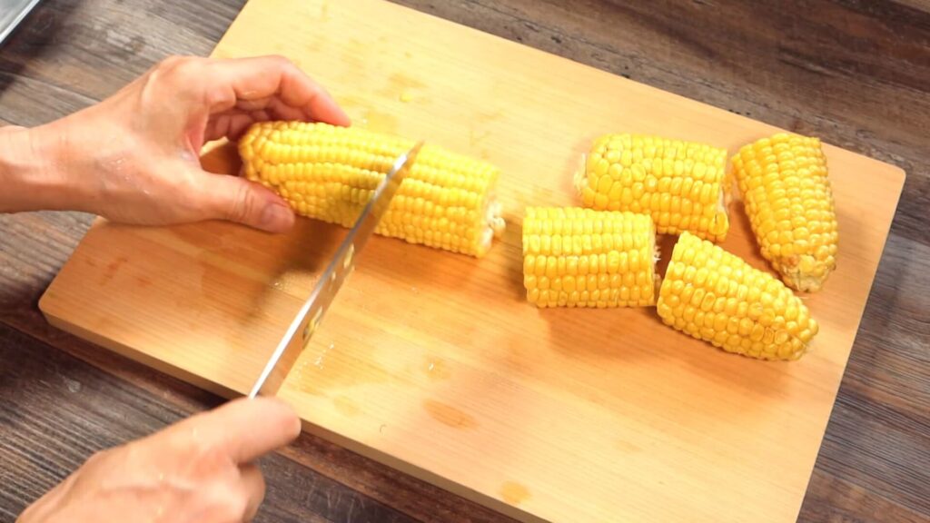 とうもろこしを３等分に切っている画像