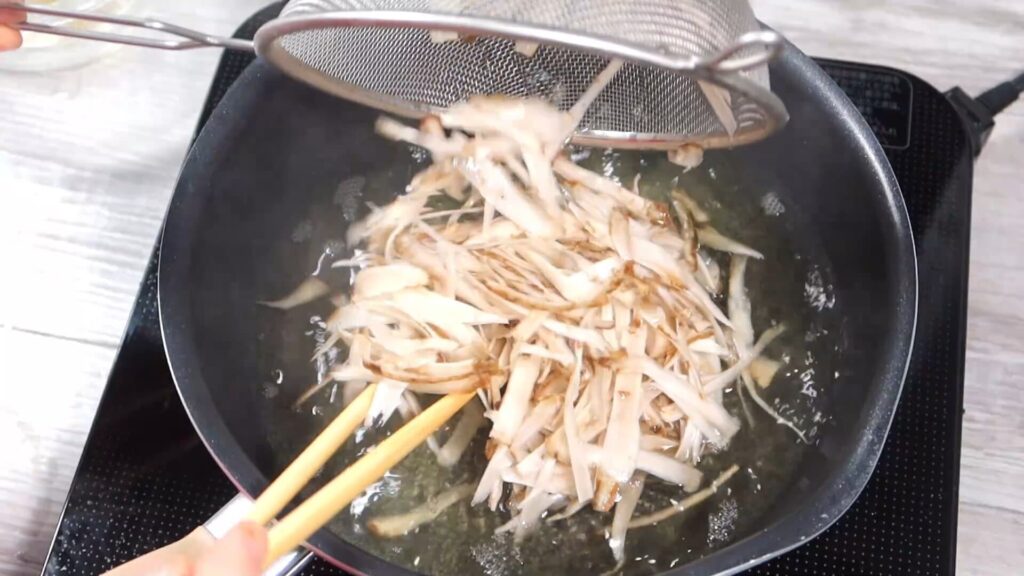 鍋にゴボウを入れている画像