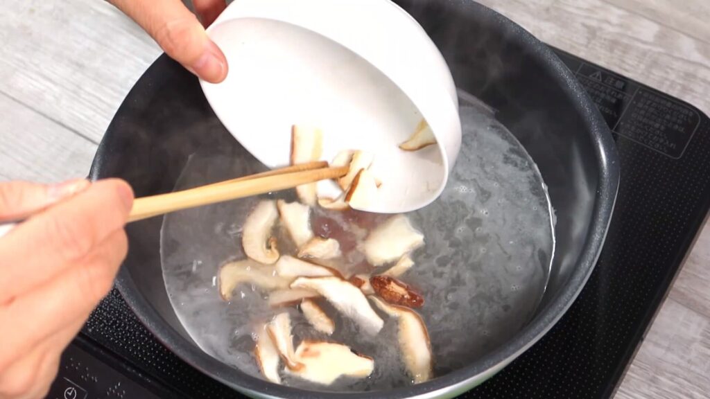 スープに椎茸を入れている画像