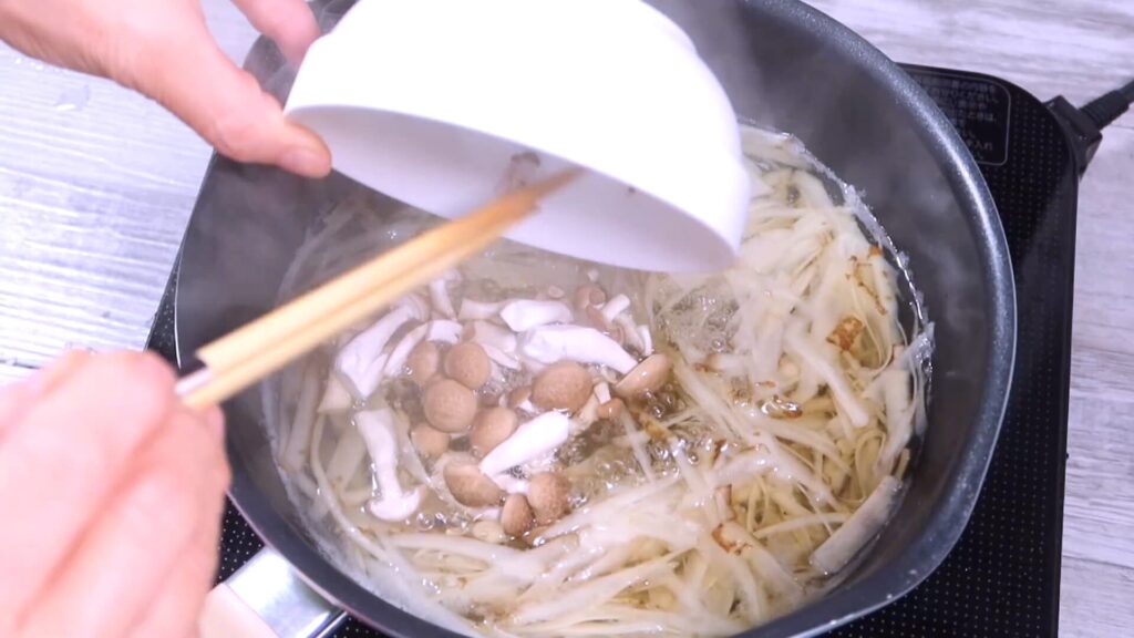 鍋にぶなしめじを入れている画像