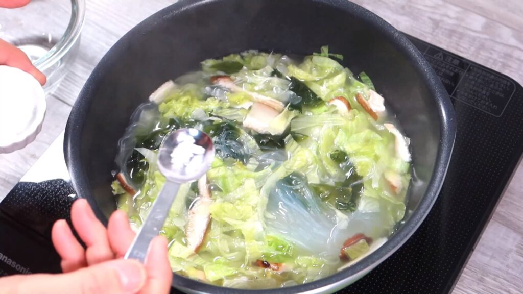 スープに塩を加えている画像