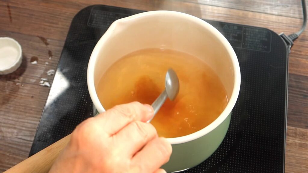 出汁に醤油を入れている画像