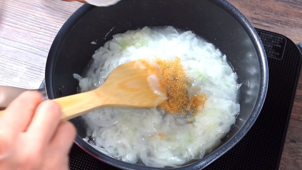 鍋にコンソメを入れている画像